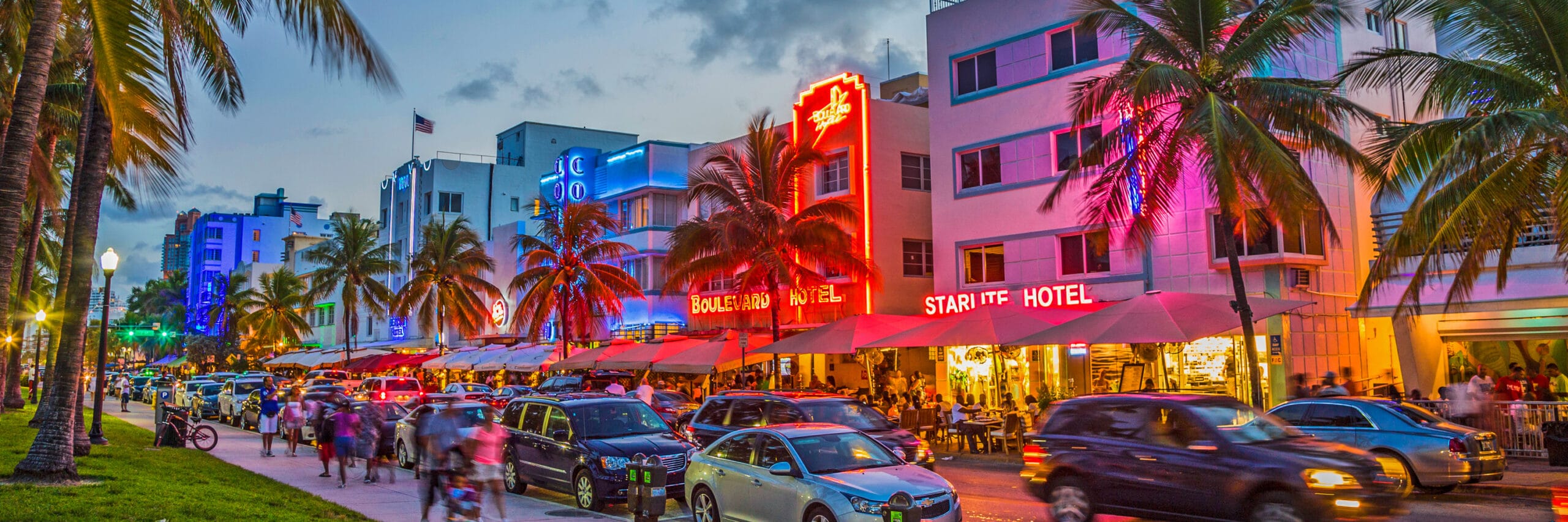 people enjoy palms and art deco hotels at Ocean Drive Miami Neon South beach
